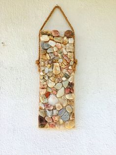 a wall hanging made out of shells and rope