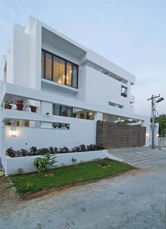 a white house with lots of windows and plants