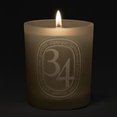 a lit candle with the number 34 printed on it in front of a black background