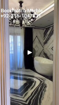 the bathroom is decorated in black and white marble with a chandelier hanging from the ceiling