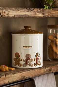 a cookie jar with gingerbreads on it sitting on a shelf