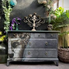 an old dresser is decorated with plants and skulls