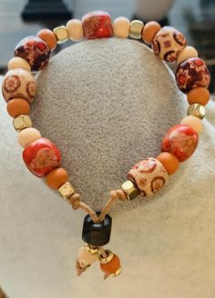 Hues of red, orange, brown and beige wooden beads strung on tan leather.  Goldtone spacer beads added as an accent.  Large beads are 10mm in size and each one has a unique design.  Small beads are 6mm in size.  Sliding clasp for an adjustable fit.  Two beads dangle at the end of the clasp. Acrylic Nails Almond Shape, Boho Necklaces, Large Beads, Almond Acrylic Nails, Almond Shape, Small Beads, Nails Almond, Brown And Beige, Bead Stringing