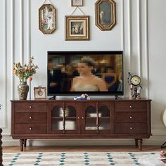 a living room with pictures on the wall and a television in the middle of it