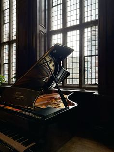 a grand piano sitting in front of a window