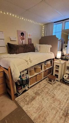 a bedroom with a bed, desk and storage drawers in front of a large window