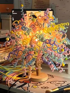 a colorful tree made out of paper on top of a desk