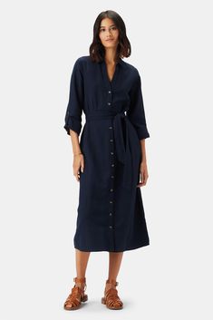 Effortlessly chic, our long-sleeved shirtdress crafted from a lightweight eco-linen blend is a versatile style you'll wear everywhere. Long-sleeved, open collar shirtdress with button front placket and detachable tie at waist Slim fit in the bodice and straight through the skirt Sleeves have a tab and button to secure when rolled up 55% Organic Cotton, 45% Linen 46" in Length This dress is designed to be slim fitting; we suggest sizing up if you prefer a more relaxed fit Ethically Made in India Navy Cord Dress, Blue Linen Dress Outfit, Linen Dress Outfit, Navy Shirt Dress, Blue Linen Dress, Button Shirt Dress, Cotton Linen Dresses, Navy Linen, Linen Midi Dress