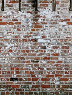 an old brick wall with pipes on it