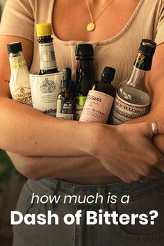 a woman is holding several bottles in her arms with the words how much is a dash of bitters?