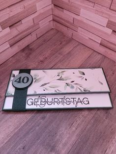 there is a sign that says gerburnstog on the floor in front of a wooden wall