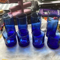 five blue glass vases sitting on top of a white towel next to each other