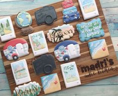 decorated cookies are arranged on a wooden board with the words, vacation and so the adventure begins