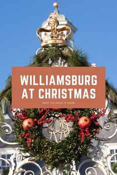 a sign that says williamsburg at christmas with wreaths and pomegranates