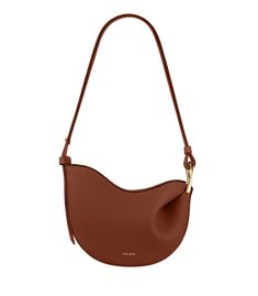 Obtained by modeling the leather on a wooden mould, the “Tonca” bag’s roundness is shaped by its folds that blend into a twisted metal buckle. The bag’s contrasting body and shoulder strap feature smooth and textured leathers. Polene Cyme Cognac, Polene Cyme Mini Cognac, Polene Numero Neuf Micro, Polene Paris Bag Tonca, Cognac Bag, Micro Bags, Twisted Metal, Upcycled Leather, Best Wallet