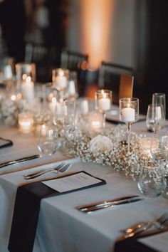 the table is set with silverware and candles for an elegant wedding reception or special event