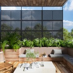 an outdoor living area with wooden flooring and plants on the roof terrace, surrounded by greenery