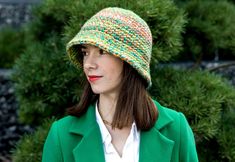 a woman wearing a green coat and a multicolored hat