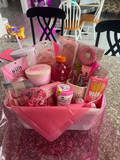 a pink basket filled with lots of items on top of a table