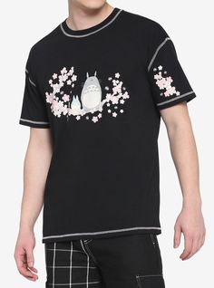 a man wearing a black t - shirt with an image of a totoro on it