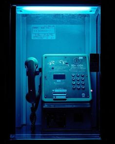 an old fashioned phone in a dark room with blue light coming from the back wall