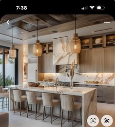 a kitchen with marble counter tops and stools in front of an open floor plan