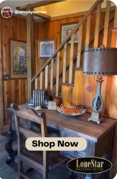 a wooden table with a lamp on top of it next to a stair case in a room