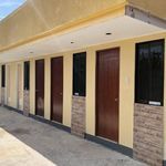 an empty parking lot with several doors and windows on each side of the building,