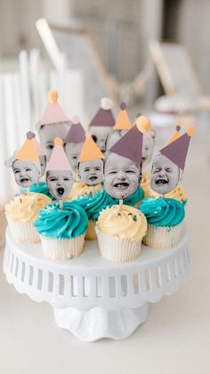 cupcakes with blue frosting and yellow icing are on a cake stand