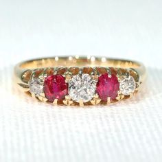 Three and five stone rings were so popular during the late Victorian and Edwardian eras that it's a wonder they produced anything else in the bustling jewelry centers of England. They come in all different combinations of diamond, sapphire, ruby, emerald, opal and amethyst, and all manner of gems. This is a great example of a five stone diamond and ruby ring, something that has not declined much in popularity in the hundred plus years since. This hand crafted ring was made in 18 karat gold in th Classic Multi-stone Round Cut Diamond Ring, Classic Three Stone Ruby Ring With Diamonds, Classic Red Diamond Ring With Single Cut Diamonds, Classic Red Ruby Ring With Single Cut Diamonds, Classic Three Stone Round Ruby Ring, Heirloom Three Stone Ruby And Diamond Ring, Heirloom Three Stone Ruby Ring With Diamonds, Heirloom Three-stone Ruby And Diamond Ring, Heirloom Three-stone Ruby Ring With Diamonds