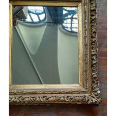 an ornate gold framed mirror hanging on the wall