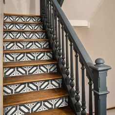 the stairs are painted with black and white tiles on them, along with wooden handrails