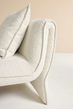 a white chair with two pillows on it's back and the seat folded up