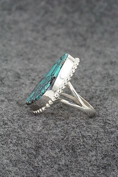 This turquoise and sterling silver ring was made by Navajo silversmith Larry Castillo. The back is signed LC and stamped sterling.Size: 7Length: 1 1/8"Width: 3/4"Free shipping on all orders! We ship with USPS and always include tracking. All orders ship within a day of payment.Returns are accepted up to 30 days after you receive your order. Just send us a message. Our shop offers cash back or store credit. The item must be returned in new condition. Southwestern Sterling Silver Turquoise Ring For Anniversary, Southwestern Turquoise Ring In Sterling Silver, Southwestern Sterling Silver Turquoise Ring, Southwestern Sterling Silver Turquoise Open Ring, Southwestern Turquoise Open Ring In Sterling Silver, Southwestern Style Turquoise Open Ring In Sterling Silver, Turquoise Sterling Silver Ring Stamped 925, Sterling Silver Turquoise Ring Stamped 925, Bear Carving