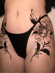 a woman's stomach with flowers and leaves tattoo on the side of her belly