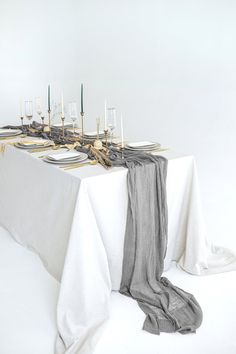 the table is set with white plates and silverware, along with napkins on it