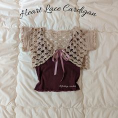 an old sweater is laying on top of a bed with the name heart lace cardigan