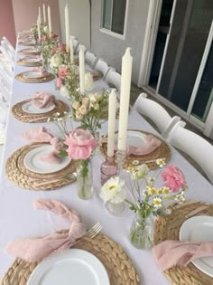 a table set with plates, napkins and flowers