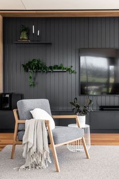 a living room filled with furniture and a flat screen tv mounted to the side of a wall