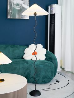 a living room with a green couch and two lamps on the side tables in front of it