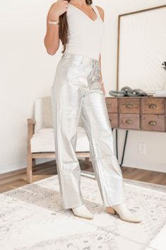 These sleek and stylish pants are made with high-quality silver leather, making them not only fun, but also durable. Perfect for adding a pop of uniqueness to your outfit, these pants are sure to turn heads and make a statement. Model is 5'5 wearing a size small XS 0-2, S 2-4, M 4-6, L 8-10 55% Polyurethane, 45% Polyester Faux leather material High-waisted Wide leg fit Modern Metallic Straight Leg Pants, Metallic Shiny Straight Leg Bottoms, Chic Metallic Shiny Pants, Metallic Shiny Spring Pants, Trendy Metallic Leather Pants For Party, Trendy Metallic Pants For Fall, Trendy Metallic Full-length Pants, Trendy Metallic Full Length Pants, Shiny Straight Leg Leather Pants For Party