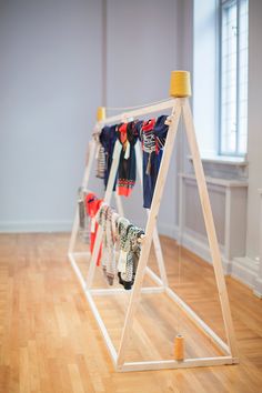 a rack with clothes hanging on it in an empty room