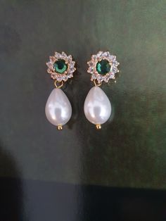 Amazing and OOAK Emerald green earrings, leave stunning impression on everyone! Very classic and has a glamour that can be achieved only with this white pearl and green stone crystals combination: beautiful Swarovski white drop pearls and green Emerald surrounded with tiny crystal Swarovski rhinestones.    I have a matching necklace: https://www.etsy.com/il-en/listing/90528659/bridal-necklace-genuine-emerald-stone?click_key=e18de233524584b28d69e078e8931ba7e38d1eef%3A90528659&click_sum=32f349a7&ref=shop_home_active_9&sts=1 A gorgeous shiny drop pearls earrings features Elegance and style: A beautiful pair made of golden filigree set with Swarovski rhinestone and vintage style pearls, tiny clear crystals and teardrop pearls that has such an impressive style. The back of the earring is ear pi Crystals Combination, Delicate Bridal Earrings, Emerald Green Earrings, Earrings Emerald, Ivory Earrings, Pearls Earrings, White Pearl Earring, Rhinestone Wedding, Ivory Pearl