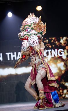 a woman is walking down the runway in an elaborate costume and headdress,