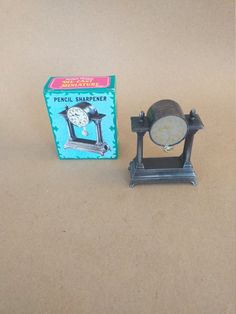 a small metal clock sitting next to a box