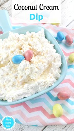 a blue bowl filled with whipped cream and candy candies on top of a table