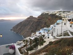 a view of the ocean and cliffs from a cliff side restaurant in oia, greece