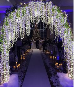 the aisle is decorated with flowers and candles