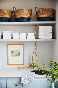 the shelves are filled with towels and other items in this kitchen, along with baskets