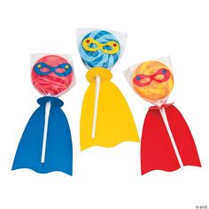 three candy lollipops in different colors and shapes with masks on the top